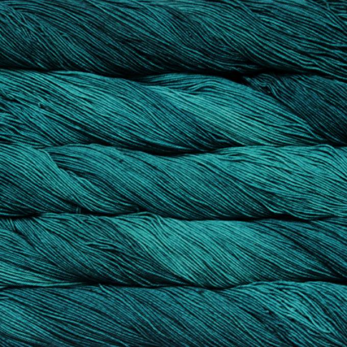 A close-up image of skeins of Malabrigo Sock yarn in teal.