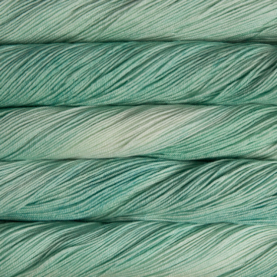 A close-up image of skeins of Malabrigo Sock yarn in pale green shades.