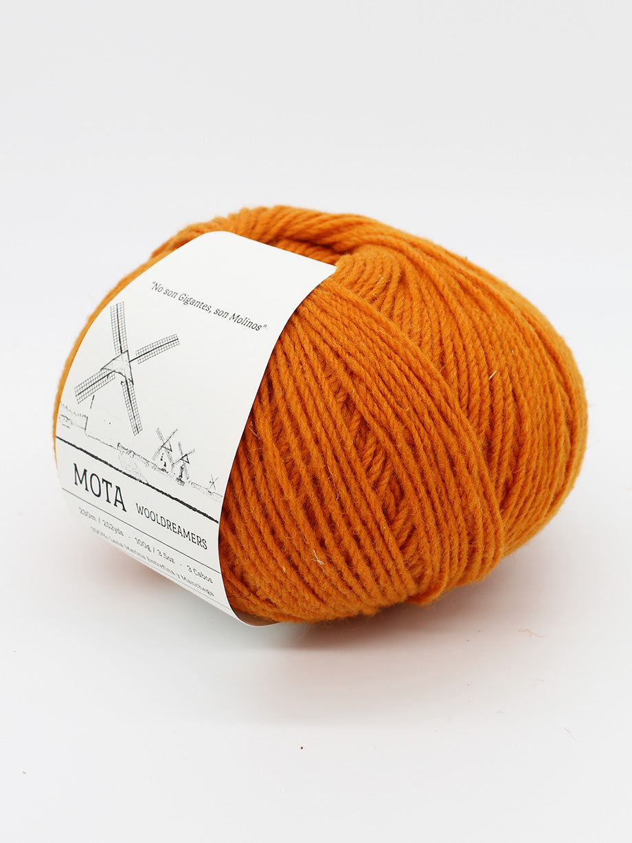 A skein of pumpkin orange yarn on a white background.